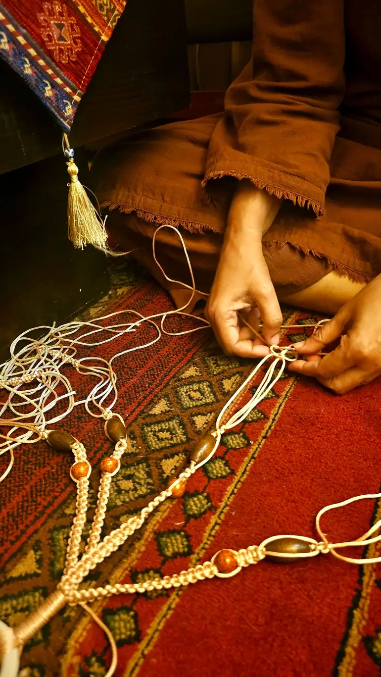 Close-up of hands knotting cord by hand